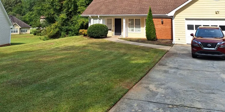 A residential house with a parked car in front.